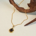 Minimalist gold necklace with a round dark gemstone pendant on a sandy background - Gold Chain Dark Stone Pendant (XL-868J)