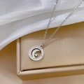 Detailansicht der silbernen Stern-Mond-Halskette auf einer goldenen Geschenkbox mit Seide - Silber
