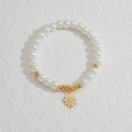 Close-up of white beads bracelet with a delicate yellow daisy flower charm on stone - Daisy Pendant Pearl Beaded