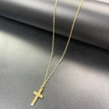 Dettaglio della collana a croce in acciaio inossidabile dorato su base industriale scura - Catena Singola Oro