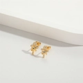 Gros plan de boucles d'oreilles œil d'Horus dorées avec pierre bleue et zircons - Œil d'Horus/Symbole Ankh / Doré