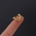 Golden crown helix earring with sparkling cubic zirconia on a fingertip display - Crown Leaf Style (315-7#G)