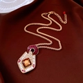 Dettaglio di collana dorata vintage con ciondolo in ambra e accenti rossi su seta scura - Collana - Oro