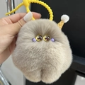 Cute beige plush monster keychain with yellow silicone ring and soft faux fur texture - Milk Coffee