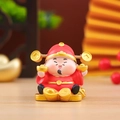 Macro view of lucky red God of Wealth resin figurine holding gold ingot for prosperity - Wealth God - Wealth from Heaven