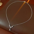 Primer plano de collar en V con circonita de gota sobre cuero marrón oscuro - Plateado