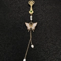 Détail de broche pompon de style chinois avec papillon doré, perles et gemme verte - Papillon