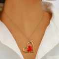 Collier avec pendentif cœur élégant en or et rouge porté sur un cou féminin - Collier Cœur Rouge