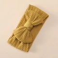 Detail of mustard yellow knit baby headband featuring a large bow and cable knit pattern - Ginger Yellow