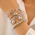 Detail view of 5-piece punk silver-tone chain and bead stacked bracelets on woman's wrist - 25 White Gold 8720