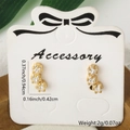 Golden starfish stud earrings with clear white cubic zirconia on a white display card - Oval Design