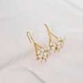 Elegant gold freshwater pearl cluster earrings on a minimalist white textured fabric - White Bohemian Style