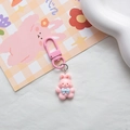 Detail of pink resin rabbit keychain with matching metal clasp and floral accessory - Pink Bow Rabbit