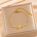 Pulsera de trébol de cuatro hojas dorada con cristales sobre fondo de seda champán - Dorado (S1125)