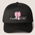 Detalle del bordado Cocktail Club con lazo rosa en gorra trucker de malla negra - Negro