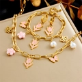 Detailed shot of a gold jewelry set featuring pink tulip, bee, and flower charms with pearls - Tulip Bee Flower Artificial Pearl 3-Piece Set (N3120 B1510 E6174)