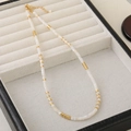 Detail of beaded choker featuring white shell beads, gold spacers, and adjustable clasp - White Cylindrical Shell Style
