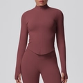 Detailed close-up of terracotta yoga jacket showing thumbholes and rib-knit texture - Brown