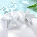 Close-up of small white resin starfish accessories on a dish with a blue water background - Small / White