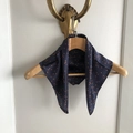 Dettaglio foulard in seta a pois arancioni su fondo blu scuro su gruccia in legno - 53x53cm / Blu navy