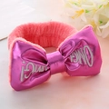 Close-up of pink plush headband with embroidered magenta OMG! bow and floral accents - Watermelon red