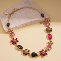 Gros plan des cristaux colorés en fleurs et larmes sur un collier doré élégant - Collier-Violet
