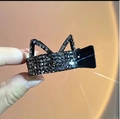 Handheld black cat ear hair claw clip with sparkling rhinestones in warm lighting - Black Cat