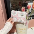 Close-up of floral quilted mini pouch being held by hand with tulips in background - Patchwork Berry