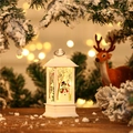 Detail der weißen Weihnachts-LED-Laterne mit Schneemann vor verschneiten Zweigen - Schneemann / Weiß