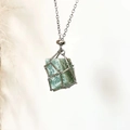 Collier cage argenté avec pendentif en pierre naturelle vert clair sur fond blanc - Aventurine Verte