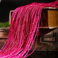 Close-up of sparkling pink flat silver wire fringe curtain draped over vintage books - 1x2m / Rose Red
