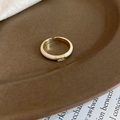 Detailed macro of cream enamel ring featuring a rectangular zircon on a vintage paper base - Adjustable Open / Cream White