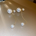 Detail of elegant gold-plated drop earrings featuring cascading white pearls on fine chains - Gold