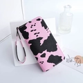 Chic long wallet with pink base and black cow pattern featuring a matching wrist strap - Pink