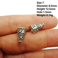 Detailed view of an antique silver alloy bead cap with intricate embossed floral patterns - Style 7