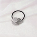 Detail of a silver leaf-shaped metal charm on a black elastic hair tie over white silk - Hollow Leaf (6) / Silver