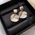 Macro detail of silver geometric drop earrings with hammered texture in a gift box - Silver