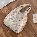 Detailansicht der Netztasche mit Blumenmuster auf rustikalem Holzboden - Westentasche Stil (Floral)