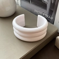 Close-up of a white three-layer geometric resin cuff bracelet on a minimalist textured surface - 3-Layer Creamy White / White