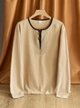 Detailopname van beige linnen Henley-shirt met contrasterende zwarte kraag en knopen - S / Khaki
