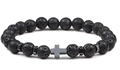 Macro detail of black volcanic lava rock beads with a metallic cross pendant on bracelet - Volcano