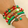 Dettaglio di braccialetti natalizi a strati con ciondoli di alberi e regali - Scatola Regalo 5 Pezzi (14)