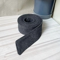 Detail of dark grey wool coat belt with diagonal cut end on grey wood background - Dark Gray