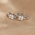 Macro detail of silver flower earrings with white zircon on silk background - Silver (Y20309)