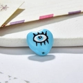 Macro view of blue heart-shaped resin evil eye beads for DIY jewelry making - Sky Blue