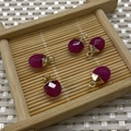 Five dark red faceted teardrop tiger eye stone pendants with gold loops on bamboo tray - No.26 Dark Red Stone