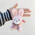 Gros plan d'un porte-clés lapin en peluche rose avec un nœud papillon et une fourrure bouclée - Porte-clés à fermoir mousqueton / 10cm / Rose