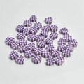 Macro shot of 10mm purple and white checkered heart clay beads for DIY jewelry making - Purple