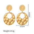Dettaglio di orecchini geometrici in oro con trama martellata e lunghezza di 5,6 cm - Rotondo Martellato / Oro