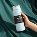 Lichtblauwe 304 roestvrijstalen vacuümgeïsoleerde sportwaterfles in de hand tegen groene stof. - 500ml / Slim Blauw (LED-deksel)